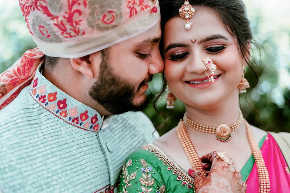 A close-up pose where the groom whispers something in the bride's ear, capturing a moment of intimate communication and laughter. 